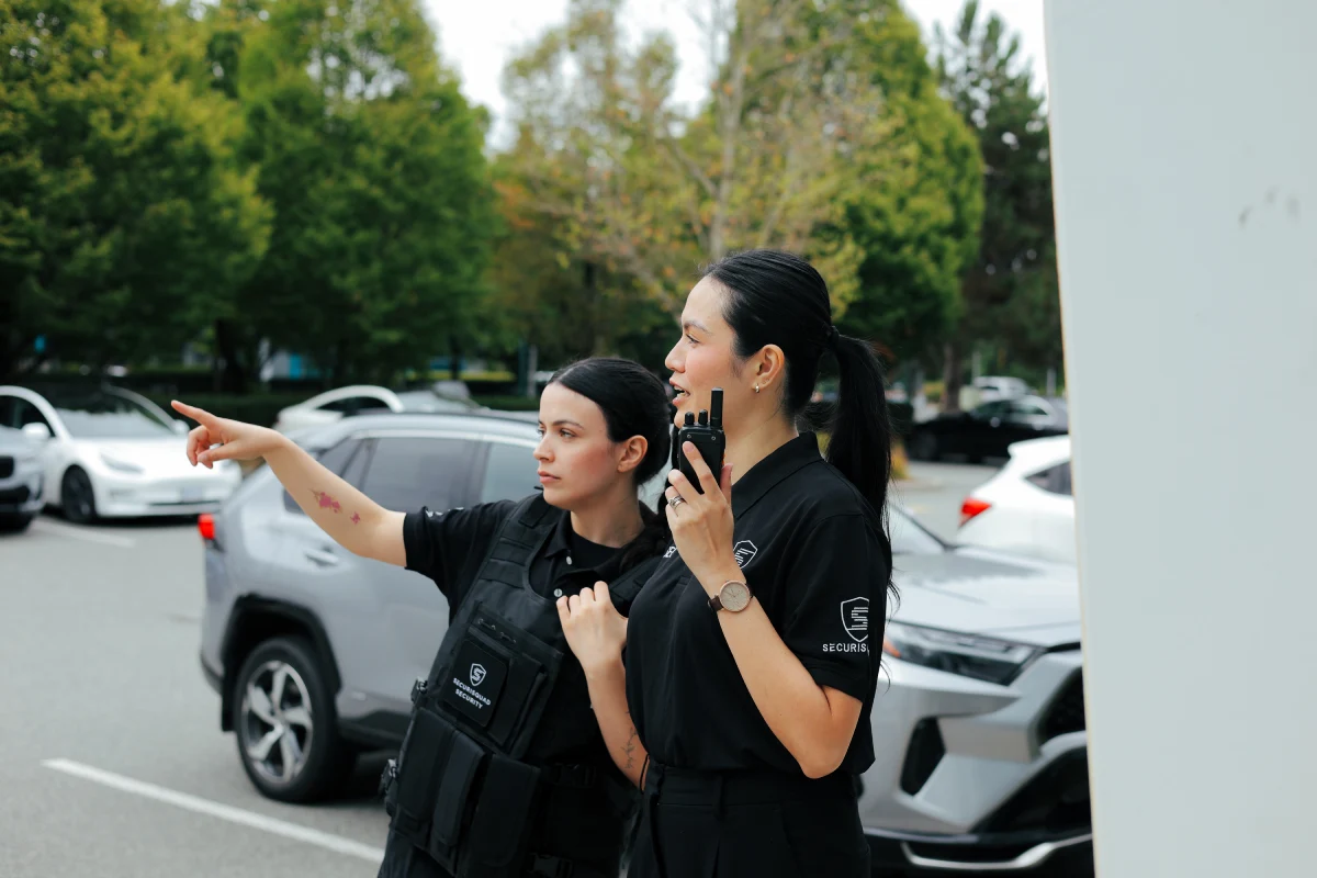 Female concierge security guard instructing another security guard at a Surrey